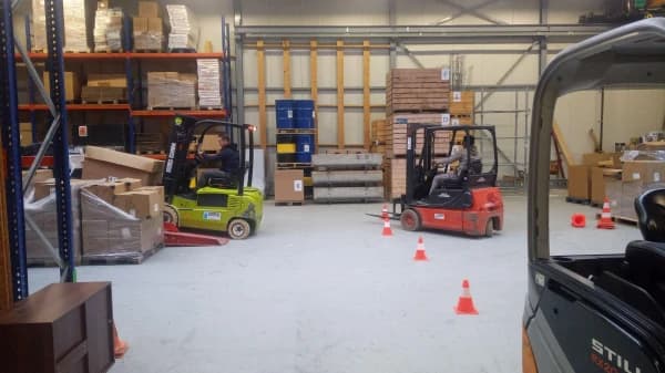 Heftruck rijdt een parcours met pionnen in de praktijkhal